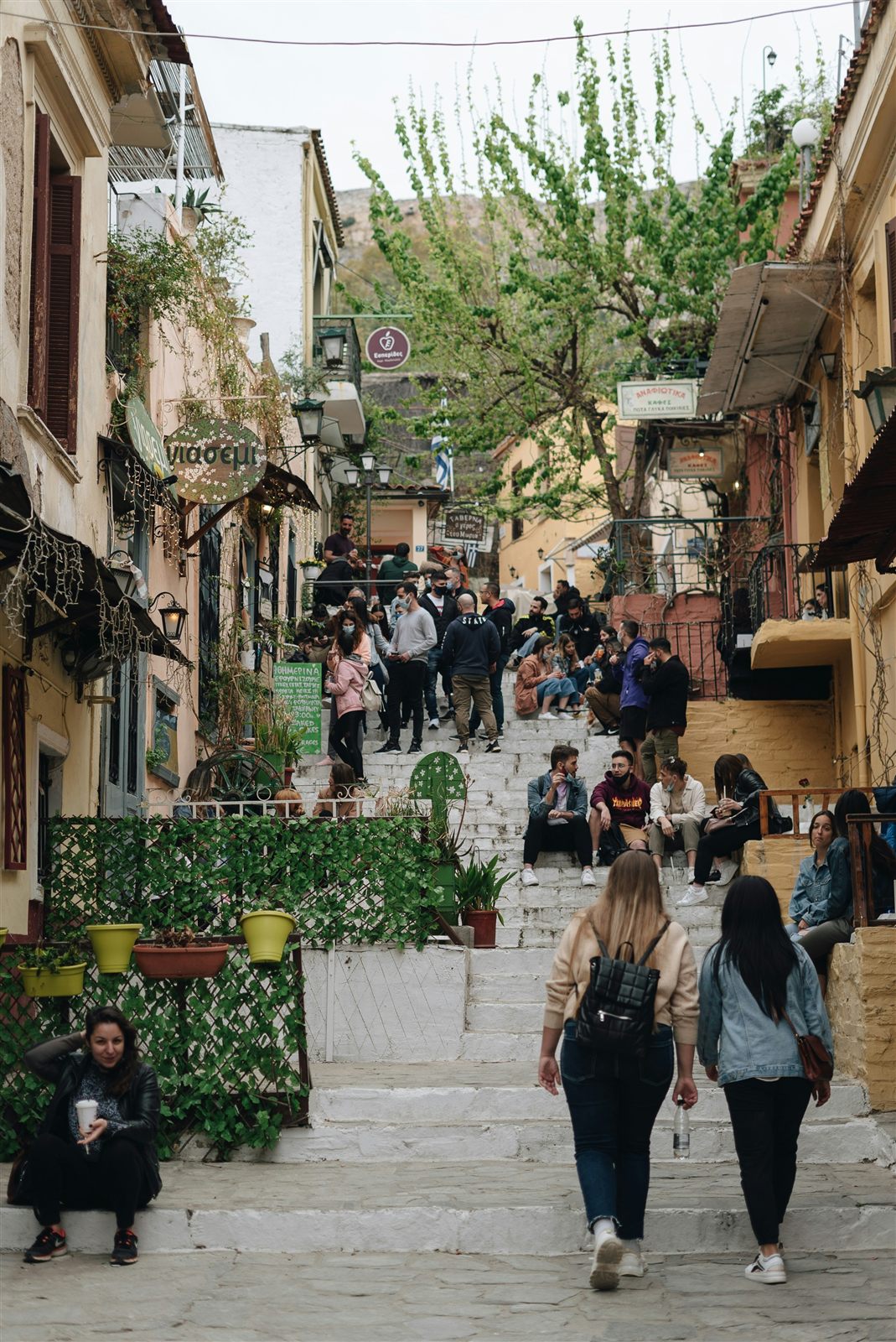 Street with people walking past shops and cafés