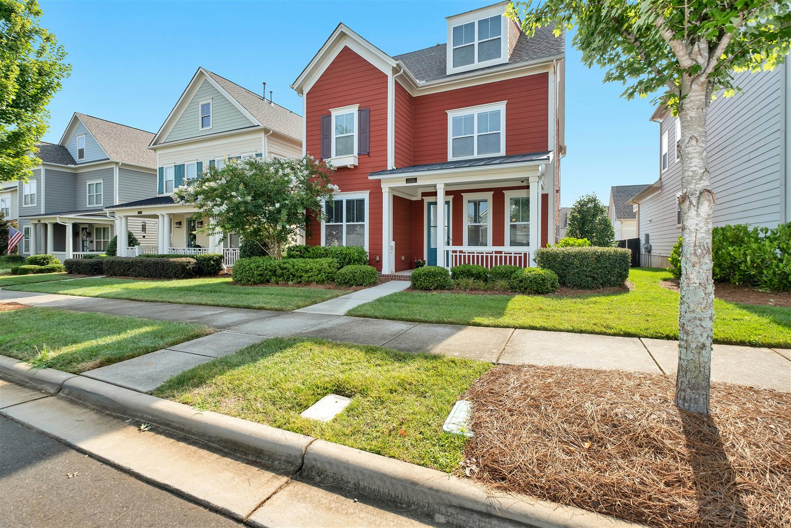 Rows of newly built homes with a red-brick house in front