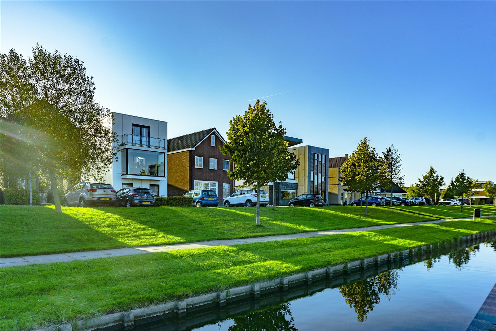 Contemporary homes beside a canal on a sunny day